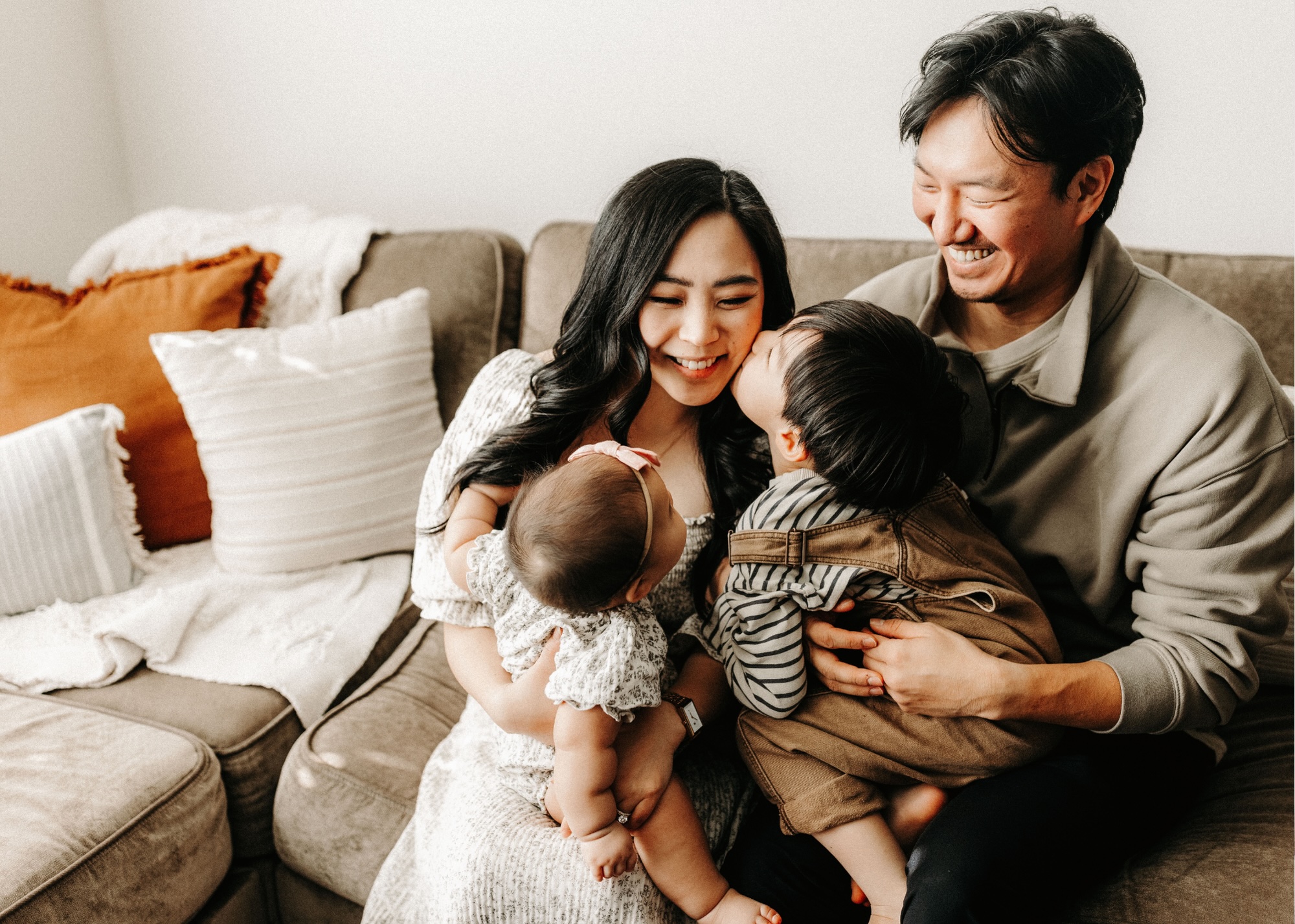 Family of four embracing at home