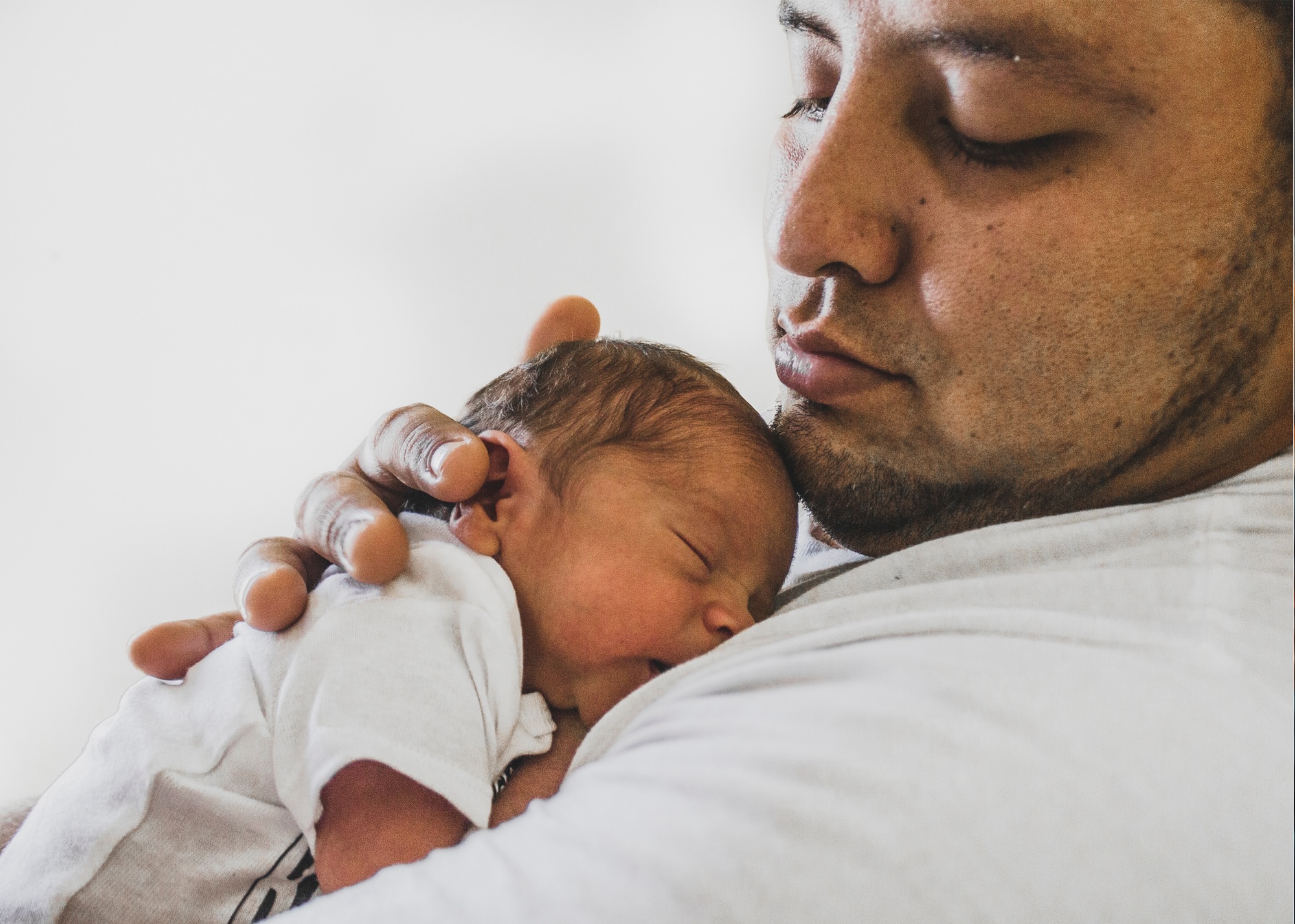 Latino parent holding newborn baby
